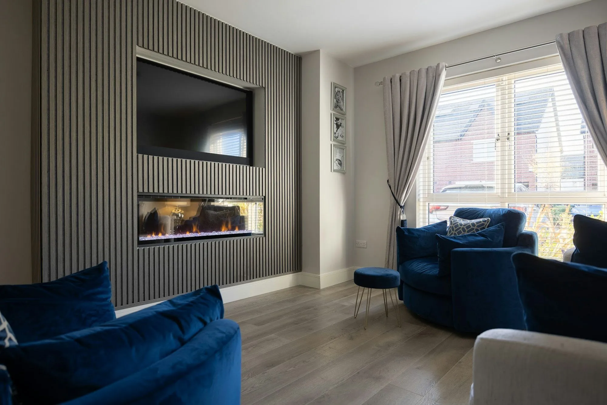 A sitting room media wall with a recessed TV and fire set into slatted panelling